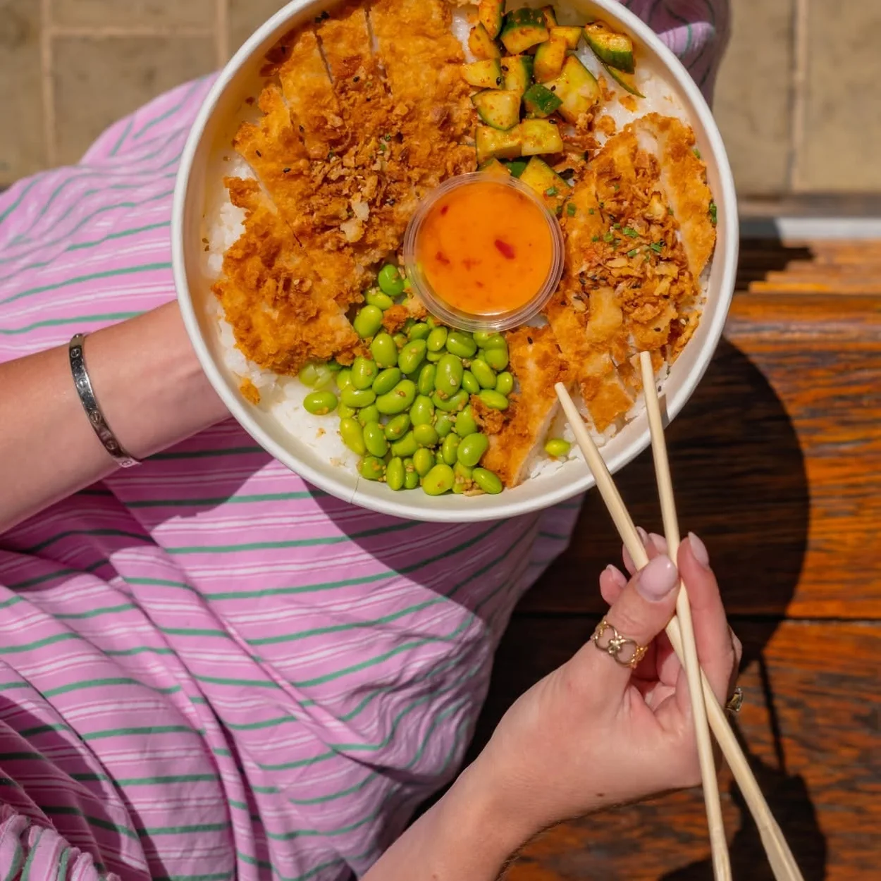 Wasabi Sushi & Bento katsu rice bowl eaten with chopsticks