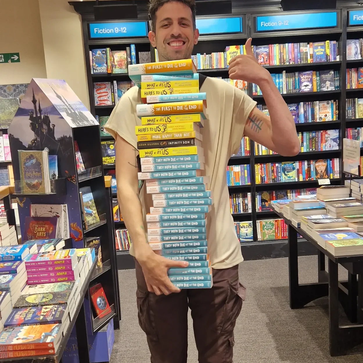 Waterstones Covent Garden bookseller with a stack of signed copies