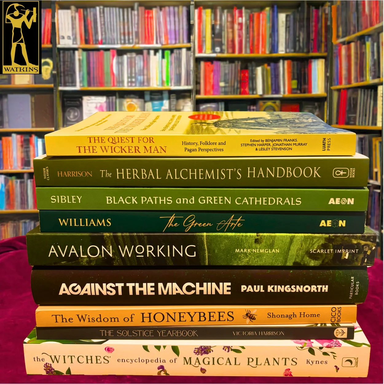Watkins Books stack of new nature and folklore titles on a red cloth