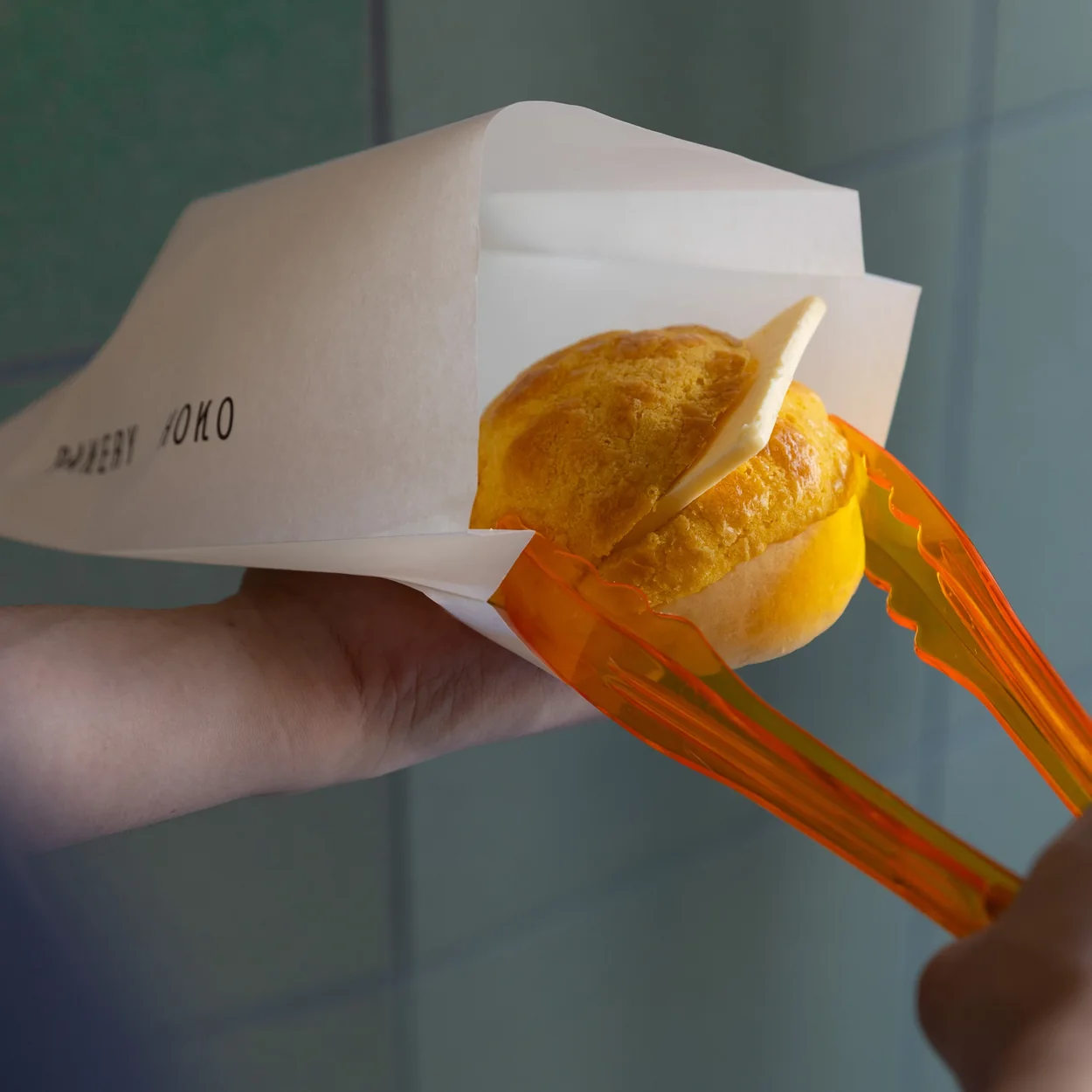 Wontons in a paper carton held in the hand at HOKO Wonton Noodles