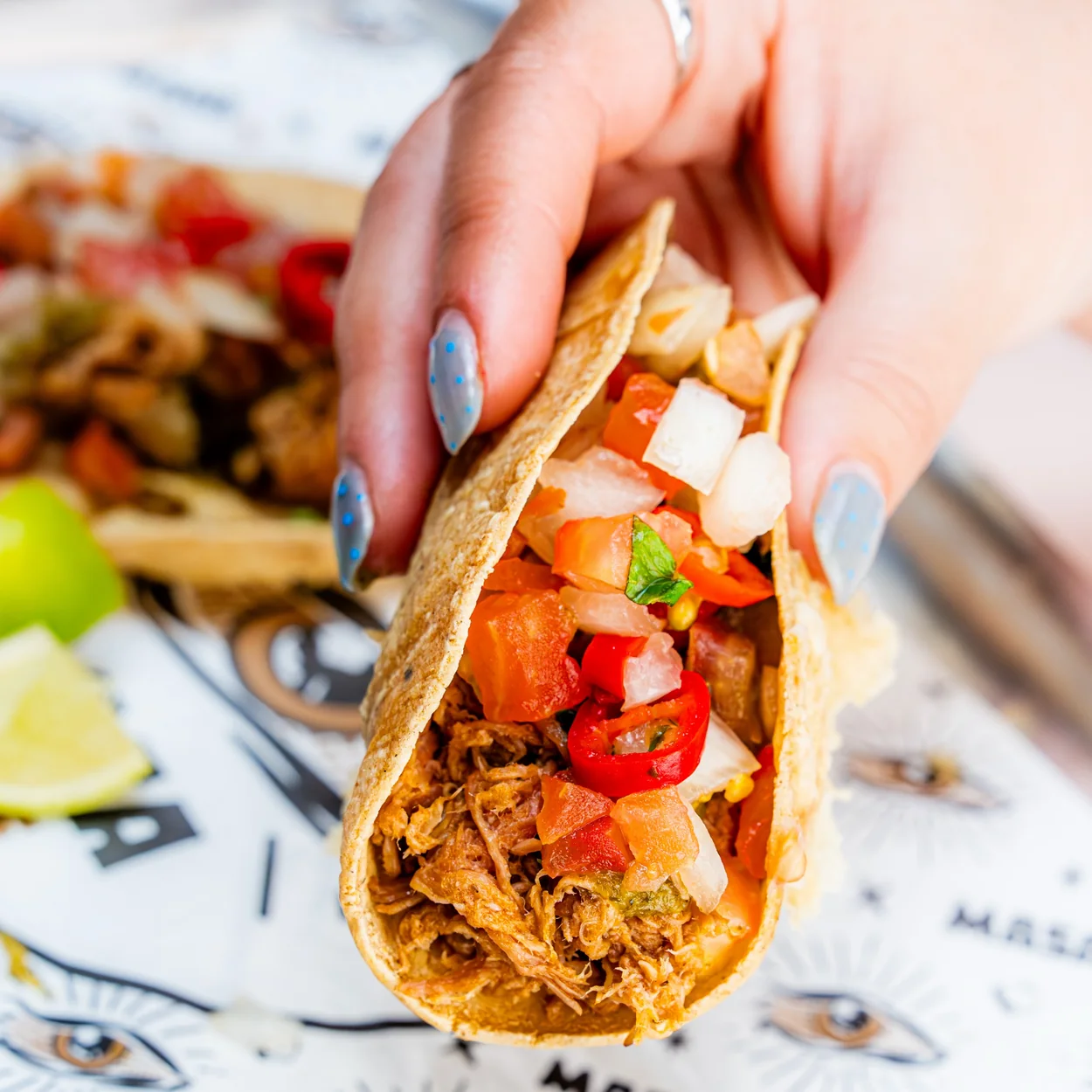 MASA taco held in hand with fresh salsa