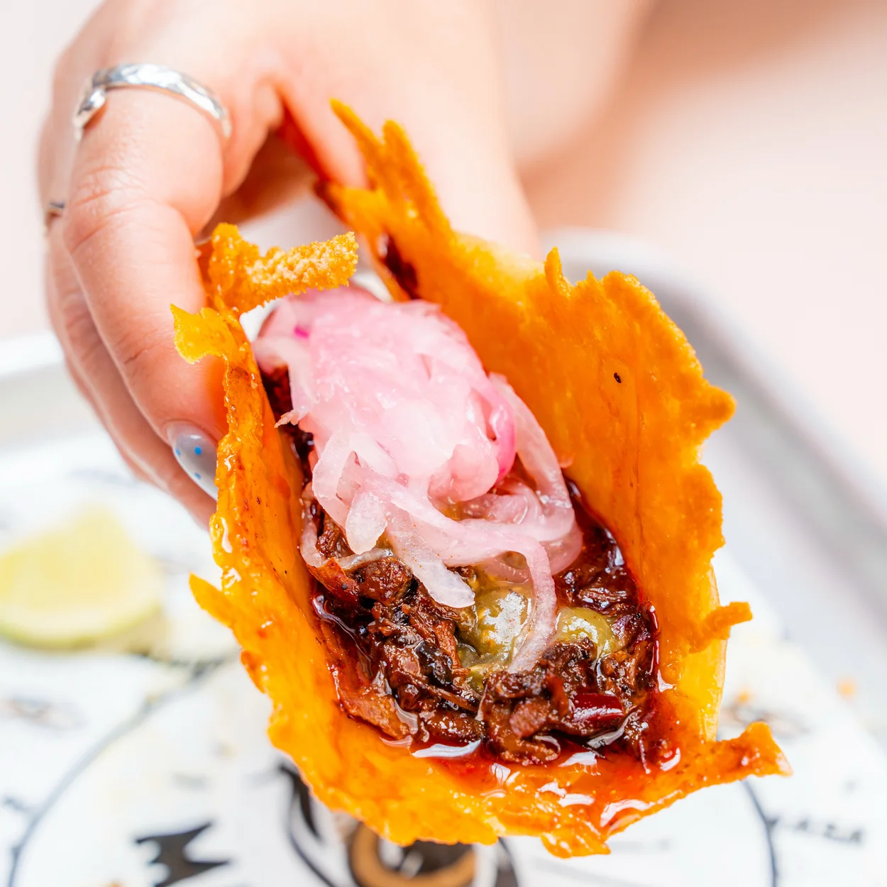 Crispy cheese taco with pickled onion at MASA Tacos