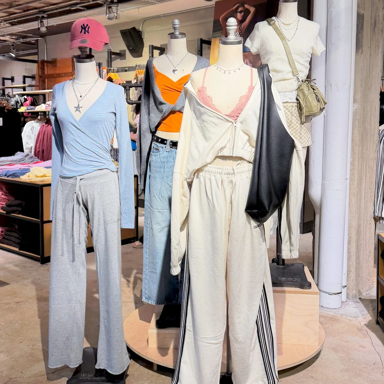 Mannequins styled in autumn knitwear and trousers inside Urban Outfitters